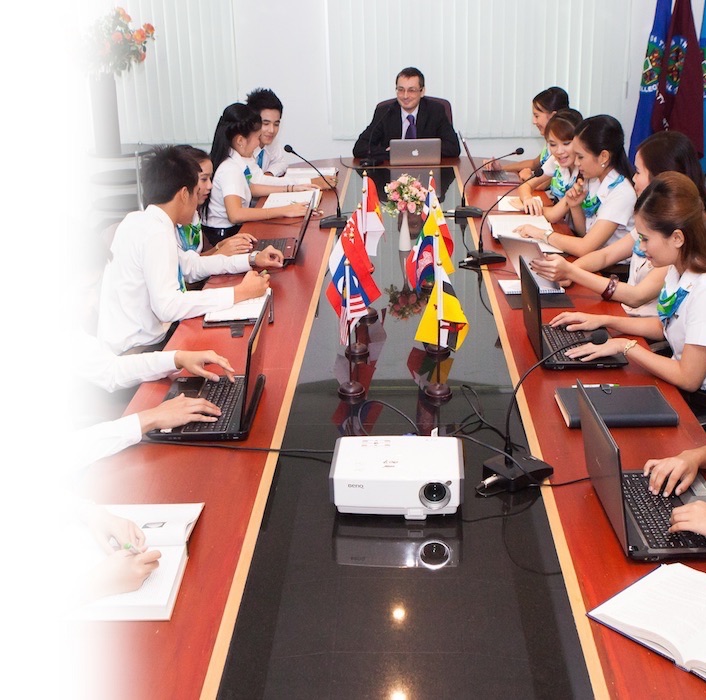 Students cooperating with their teacher in a meeting room