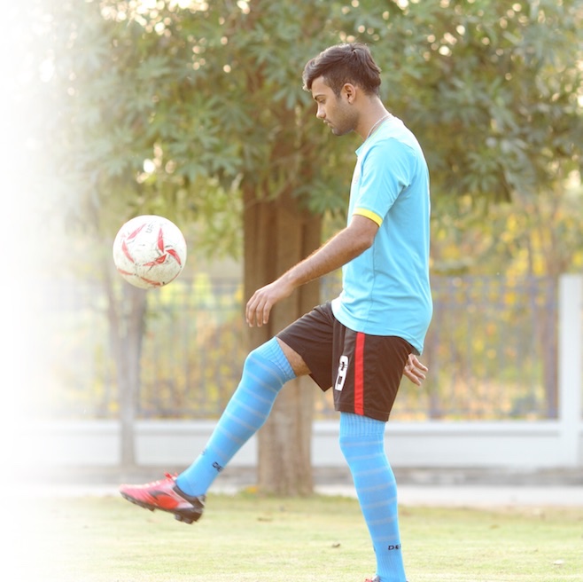 A student playing football on the University's football field